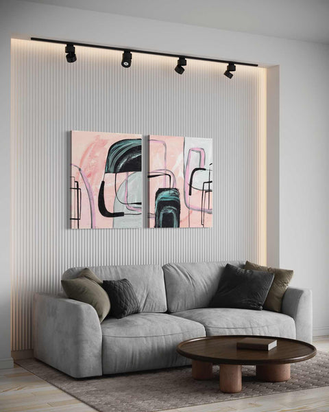 a living room with a couch and two paintings on the wall