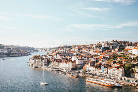 a boat traveling down a river next to a city