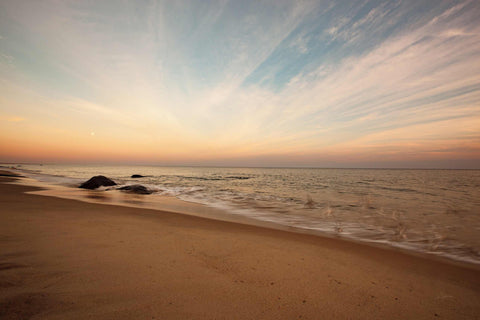 a beach that has some rocks in the sand