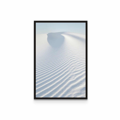 a framed photograph of a white sand dune