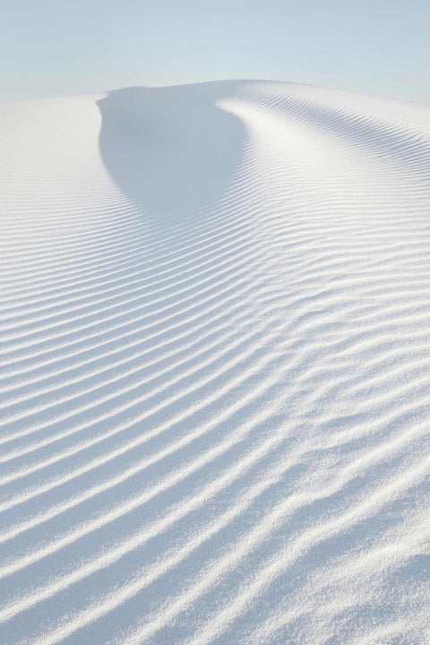 a snow covered hill with a blue sky in the background