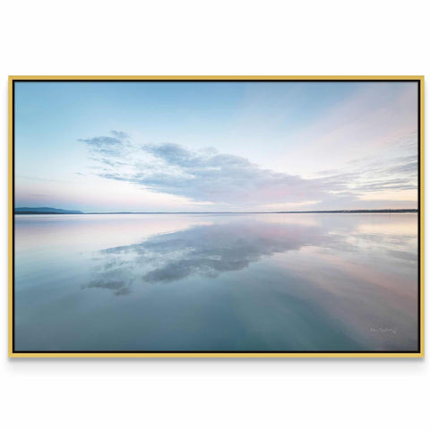 a large body of water with a sky in the background