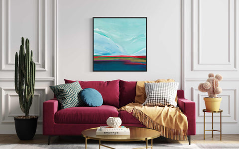 a living room with a red couch and a painting on the wall