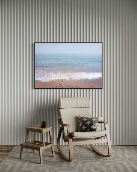 a chair and ottoman in a room with a picture on the wall