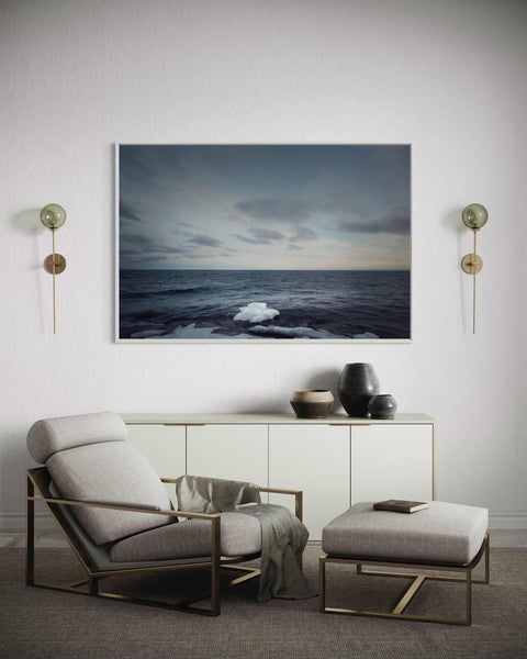 a chair and ottoman in a room with a painting on the wall