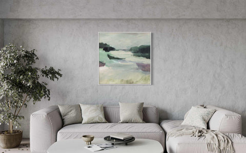 a living room with a white couch and a painting on the wall