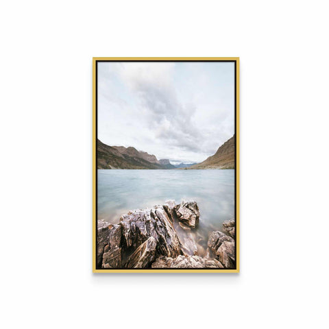 a picture of a lake with rocks and mountains in the background