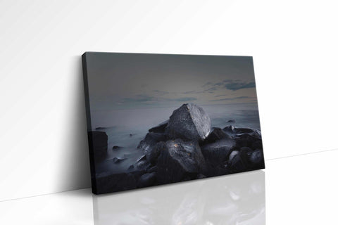a black and white photo of rocks and water