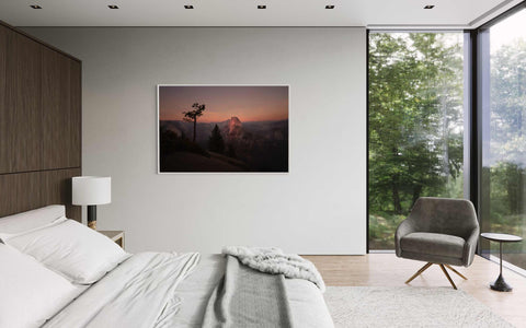 a bedroom with a bed, chair and a painting on the wall
