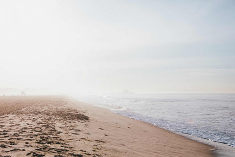 a sandy beach with footprints in the sand